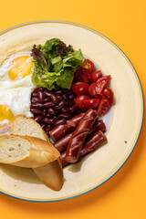 Delicious breakfast - Eggs with sausages, beans, and tomatoes
