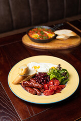 Delicious breakfast - Eggs with sausages, beans, and tomatoes