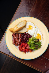 Delicious breakfast - Eggs with sausages, beans, and tomatoes