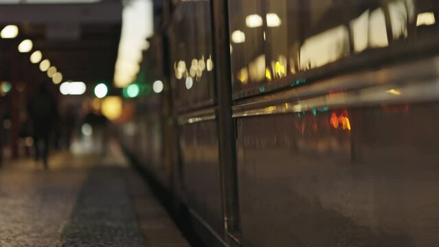 A train that is mooving next to a platform and people