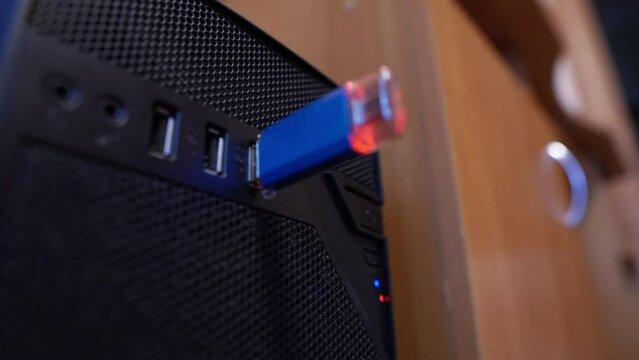 A man inserts a USB flash drive into the computers USB port and then pulls it out