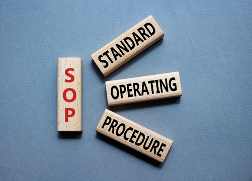 SOP - Standard Operating Procedure symbol. Wooden blocks with word SLA. Beautiful grey background. Business and Service Level Agreement concept. Copy space.
