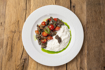 Salad with fried seasonal mushrooms, cherry tomatoes, stracciatella 