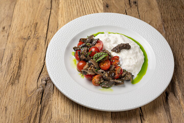 Salad with fried seasonal mushrooms, cherry tomatoes, stracciatella 