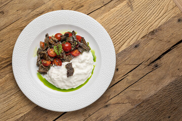 Salad with fried seasonal mushrooms, cherry tomatoes, stracciatella 