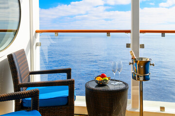 A bowl of fresh fruit, a bottle of champagne in an ice bucket, and two champagne glasses on an...