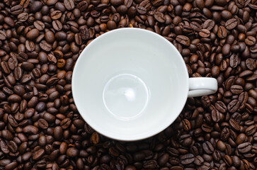 Ceramic coffee mugs placed on top of high quality roasted coffee beans.
