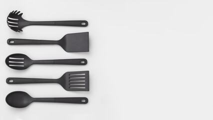Group of vertically aligned spoons and spatulas, isolated on grey copy-space background. - obrazy, fototapety, plakaty