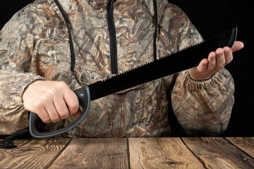 Machete in the hands of a man. A tool for survival in the forest.