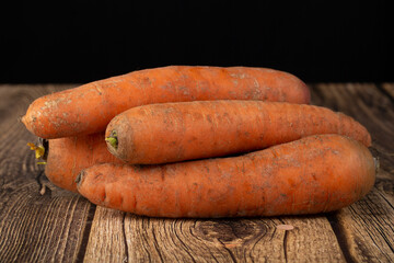 Carrots are red on a dark background. Sale of fresh carrots.