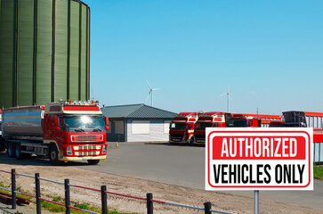 Sign with text Authorized Vehicles Only near granary and parked trucks outdoors