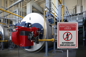 Sign with text Restricted Area Authorized Employees Only near different equipment indoors