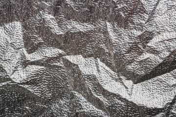 Silver crumpled foil textural background