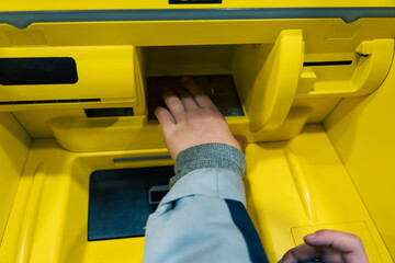 Child's Hand Using Push-Button Control Panel on ATM for Cash Withdrawal