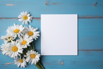 blank card mockup on blue wooden background surrounded by bouquet daisies flowers, template white sheet of paper for design