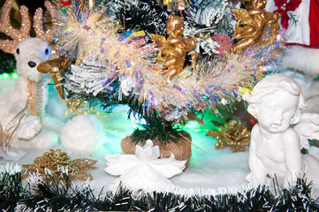 Ornamental objects around a decorated glittering Christmas tree. 