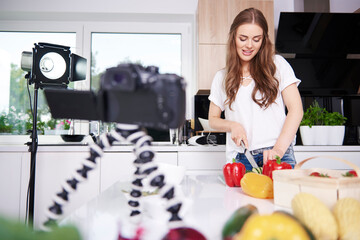 Woman recording while chopping vegetables