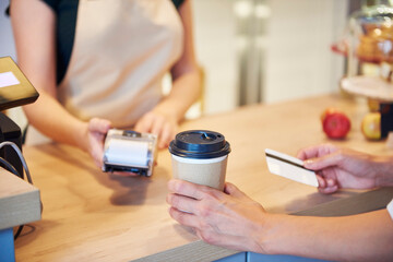 Close-up of customer paying by credit card in a cafe