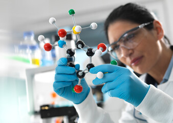 Biotech Research, Scientist examining a ball and stick molecular model of a chemical formula during...