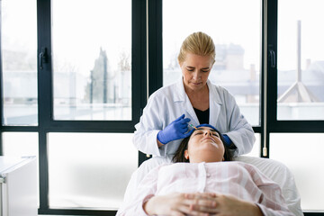 Woman receiving hyaluronic acid injection in medical practice