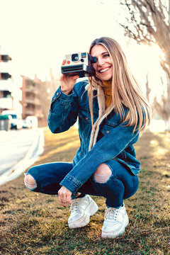 Portrait of smiling young woman using instant camera