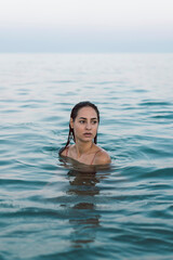 Beautiful woman at the beach, swimming in the sea