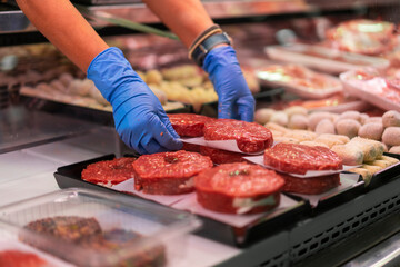 Woman at market stall preparing minced meat