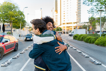 Two happy friends embracing in the city, Barcelona, Spain - obrazy, fototapety, plakaty
