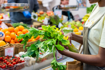 Mid section of woman buying groceries in a market hall
