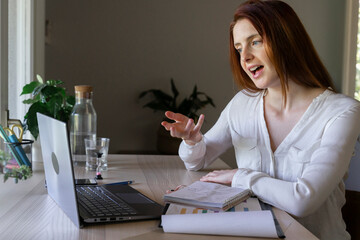 Doctor discussing on video call through laptop while sitting at home