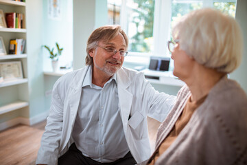 Doctor talking to a senior woman patient in his doctors office