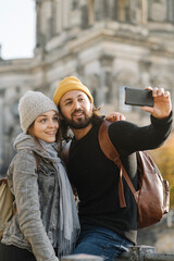 Young couple taking a selfie with Berlin Cathedral in background, Berlin, Germany