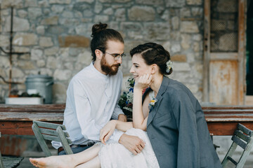 Affectionate happy bride and groom sitting at table