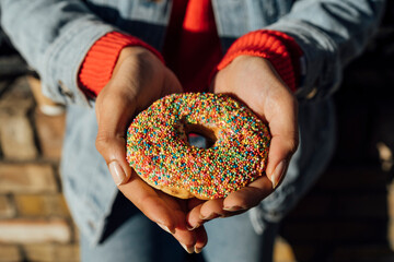 Close-up of young woman hands holding donut