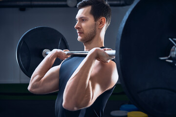 Man doing push press barbell exercise at gym
