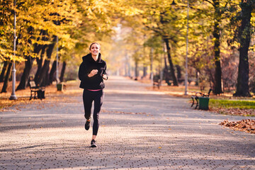 Young woman jogging in autumn forest