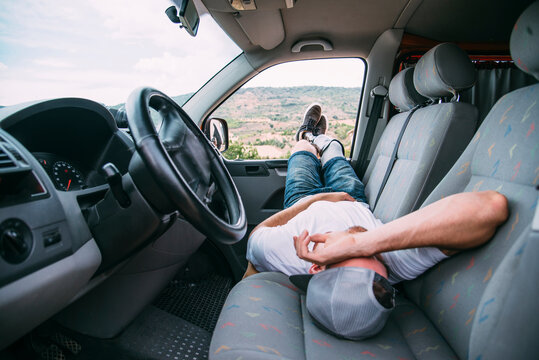Young man with leg prosthesis resting in camper van - Powered by Adobe