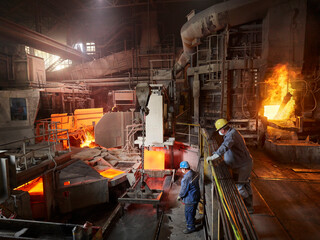 Industry, Worker lifting copper plates with indoor crane for cooling in water basin