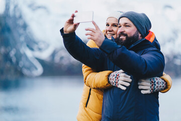 Tourist couple taking a selfie at Hamnoy, Lofoten, Norway - obrazy, fototapety, plakaty