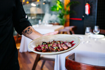 Close-up of man serving a dish in restaurant