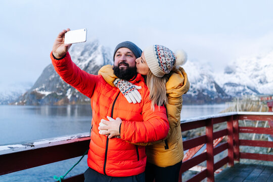 Tourist couple taking a selfie at Hamnoy, Lofoten, Norway