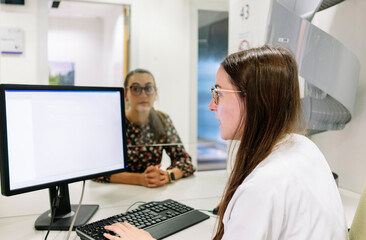 Female pharmacist looking patient's record over computer in hospital