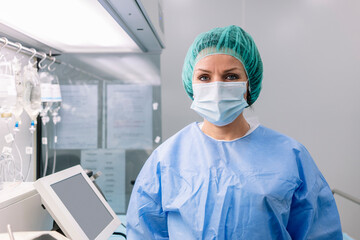 Female pharmacist wearing medical scrubs standing in laboratory