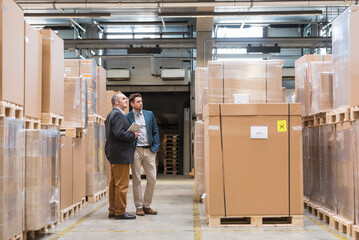 Two men standing in factory warehouse