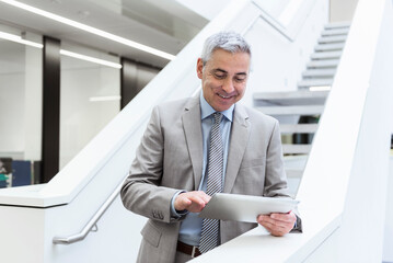 Portrait of a mature businessman, using digital tablet