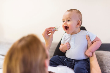 Mother and baby son playing with pacifier