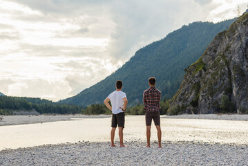 Germany, Bavaria, back view of two friends looking at view at riverside