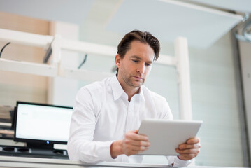 Businessman using tablet in factory