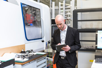 Businessman using tablet in modern factory