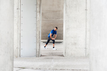 Man stetching at an underpass